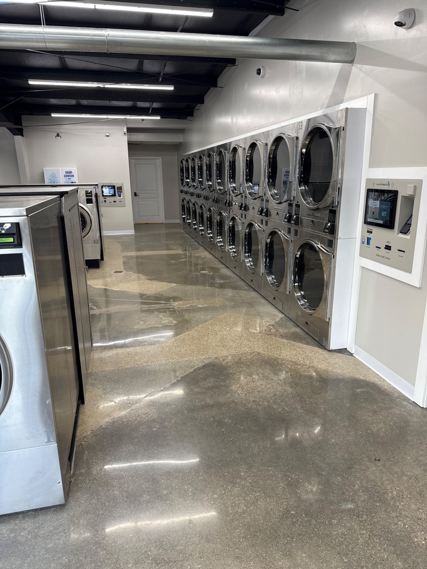 Bright aisle lined with stacked dryers
